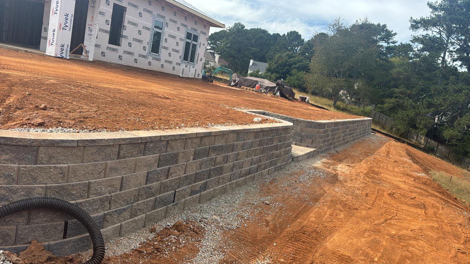 Long curved segmental block retaining wall along a graded yard