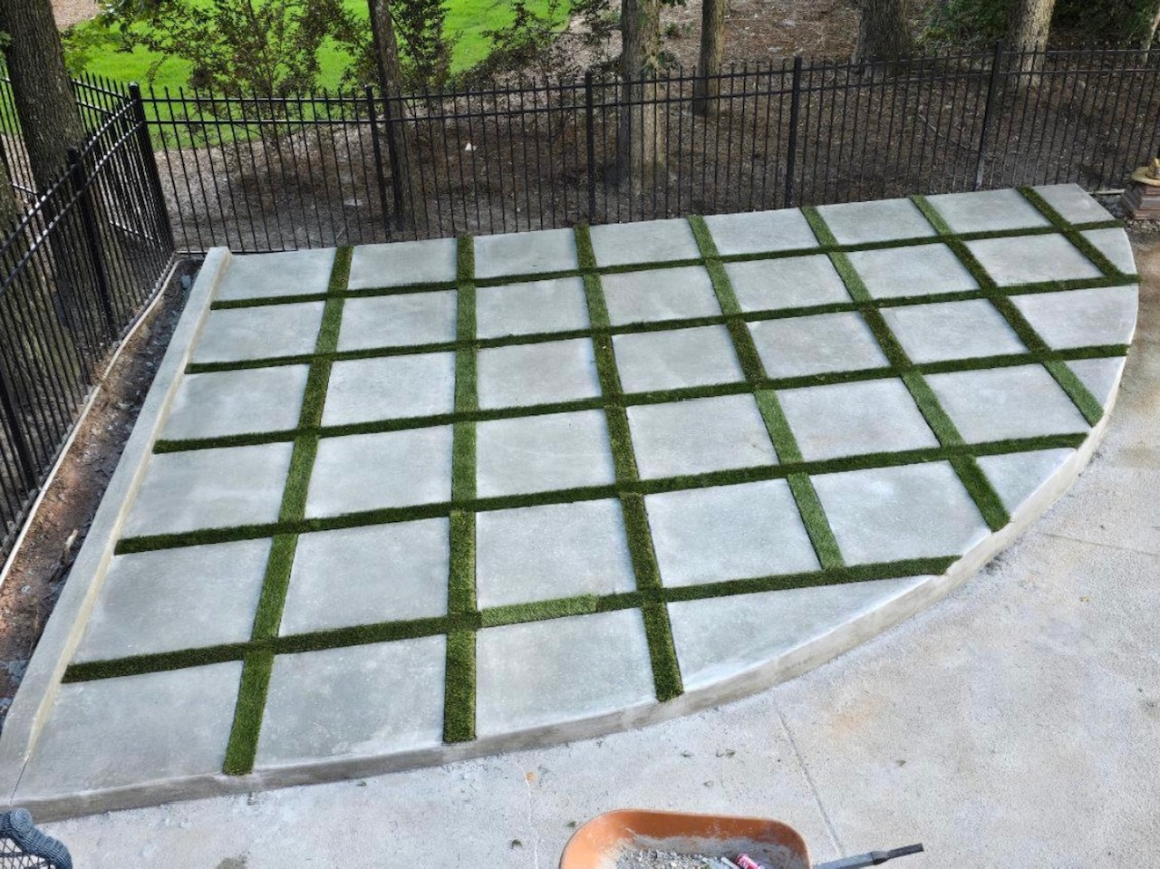 Semi-circular patio with turf grid between concrete panels